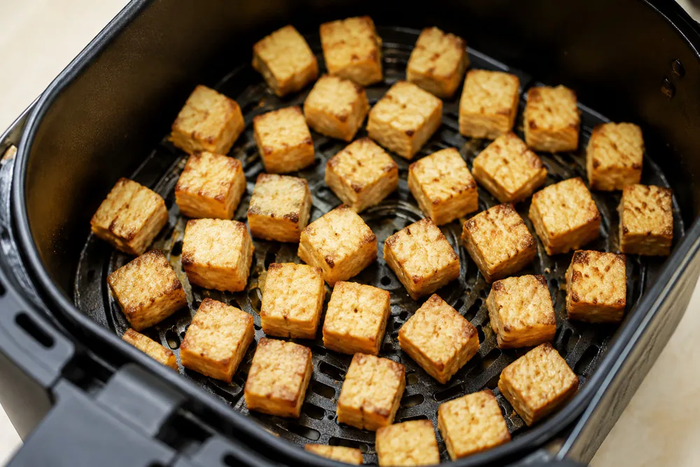 Golden cubes of crispy air-fried tofu in a single layer.