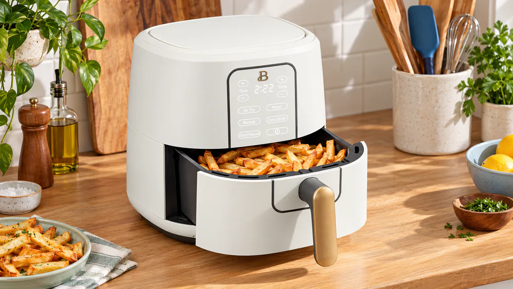 The Beautiful 6 Qt basket pulled halfway out of the drawer holding about two pounds of golden frozen fries