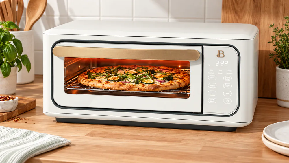 Beautiful Infrared Air Fryer Toaster Oven on a kitchen counter with a 12-inch pizza on the rack and its interior light on