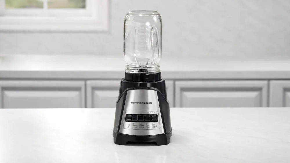 A Hamilton Beach Power Elite blender with a small-mouth mason jar fitted onto the blade assembly for a single-serving blend.
