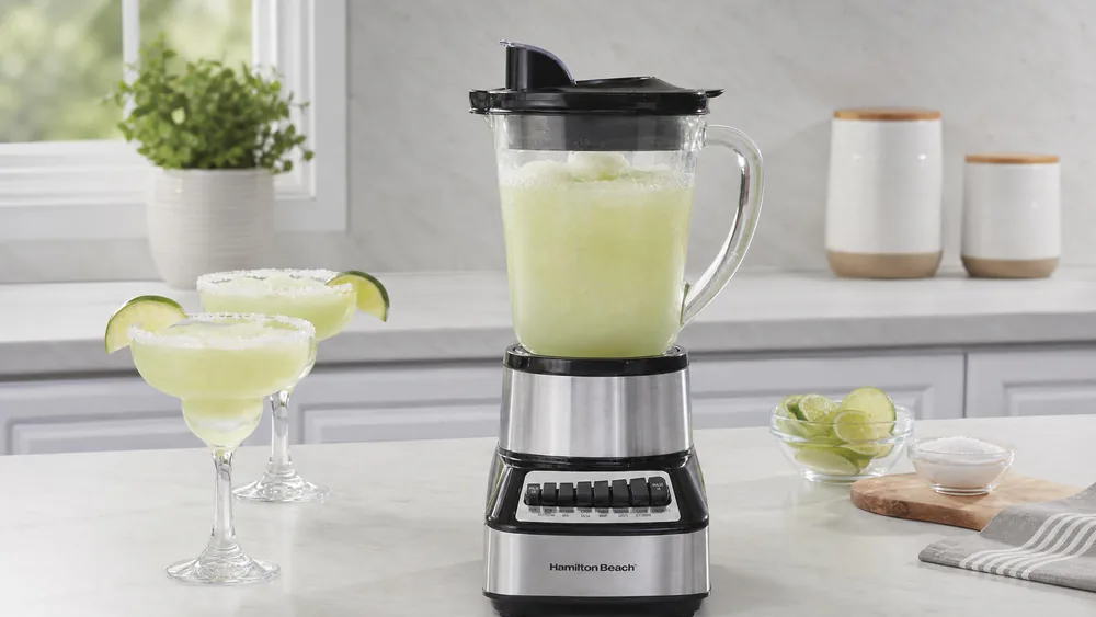 A Hamilton Beach Wave Crusher with its 40-ounce glass jar filled with a frozen drink, fine crushed ice floating on top.