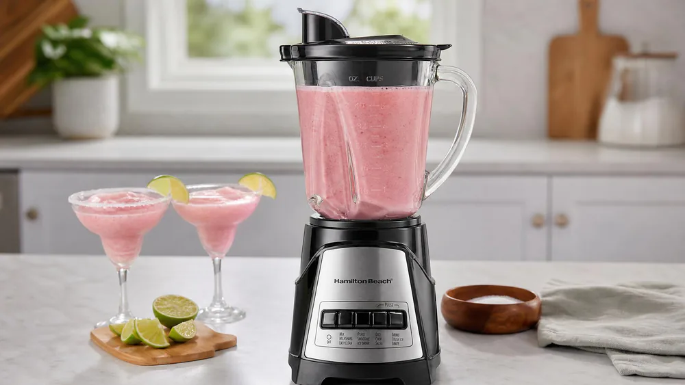 A Hamilton Beach Power Elite 58148A with its 40 oz glass jar filled with a pink frozen drink, sitting on a kitchen counter.