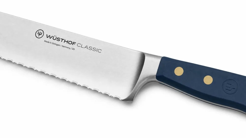 A Wüsthof Classic double-serrated bread knife, close-up on the serration-within-a-serration edge and triple-riveted handle.