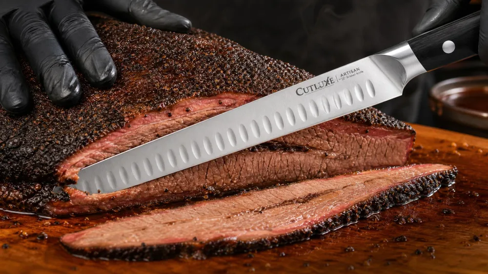 The Cutluxe 12-inch brisket knife cutting a clean, even slice from a whole smoked brisket, bark intact and juices pooling.