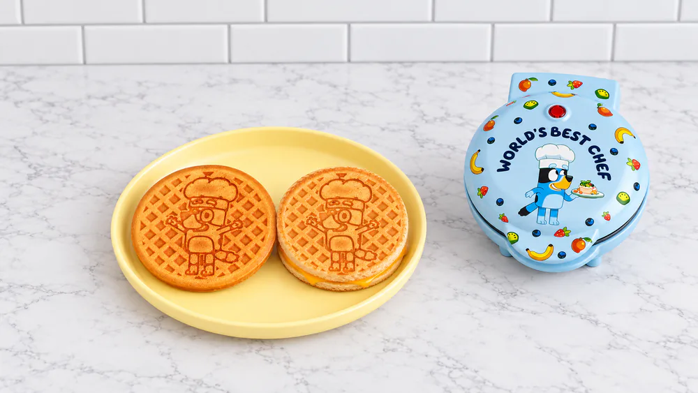 A round waffle with a Bluey imprint and a Bluey-pressed sandwich side by side on a child's plate