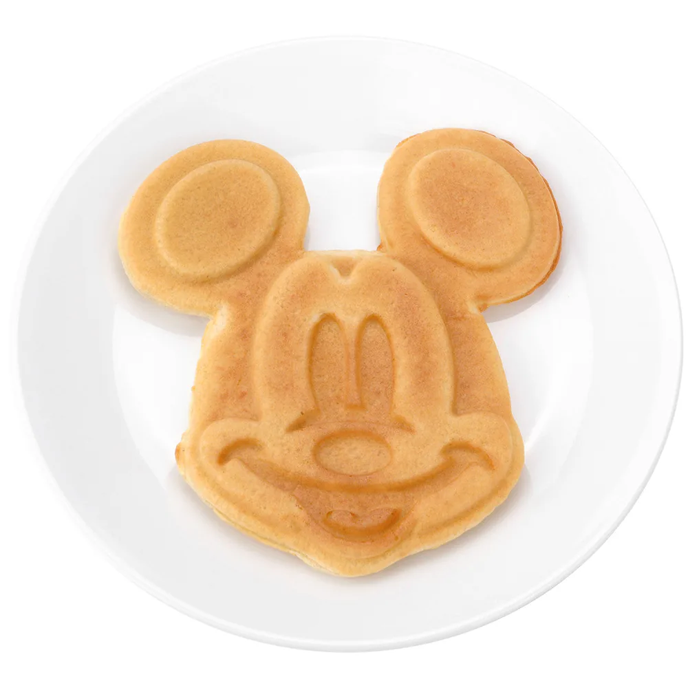 A golden Mickey-shaped waffle on a white plate in the manufacturer product photo