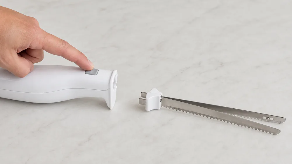 A hand pressing the blade release button as a serrated blade lifts free for cleaning.