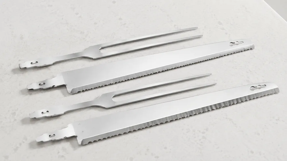 A close-up of two electric knife blades side by side, one micro-serrated and one standard, showing the fine serrated edges.