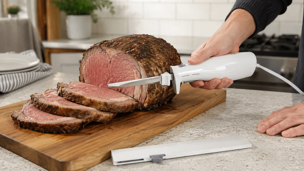 A Proctor Silex 74312J cutting thick slices from a prime rib, blade sleeve on the counter.