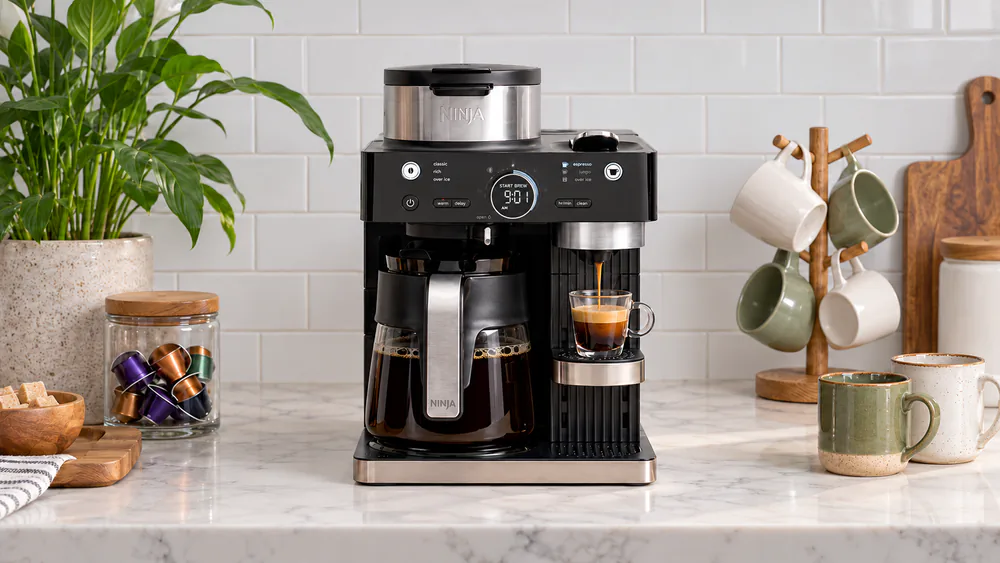 Ninja CFN601 Barista System with a capsule espresso shot in a cup on one side and a full glass carafe of drip coffee on the other