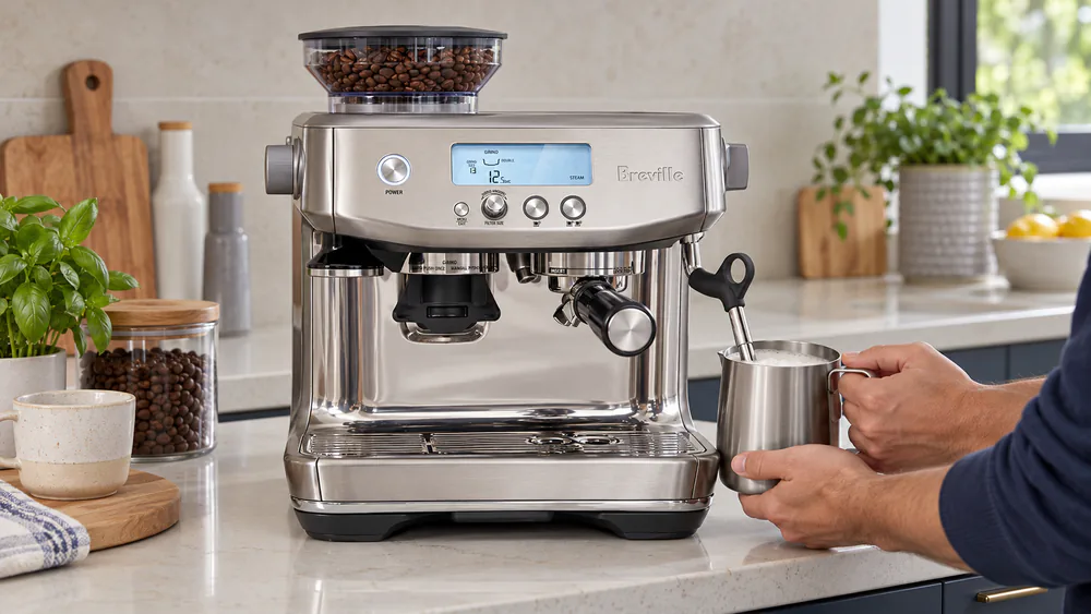 Breville Barista Pro steam wand texturing milk in a stainless pitcher with the LCD screen glowing in the background
