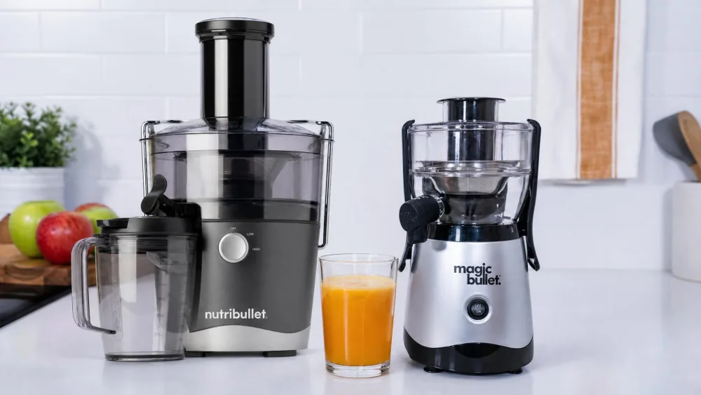 The Nutribullet NBJ50100 and the Magic Bullet Mini juicer side by side on a small kitchen counter with a single 16-ounce glass of juice