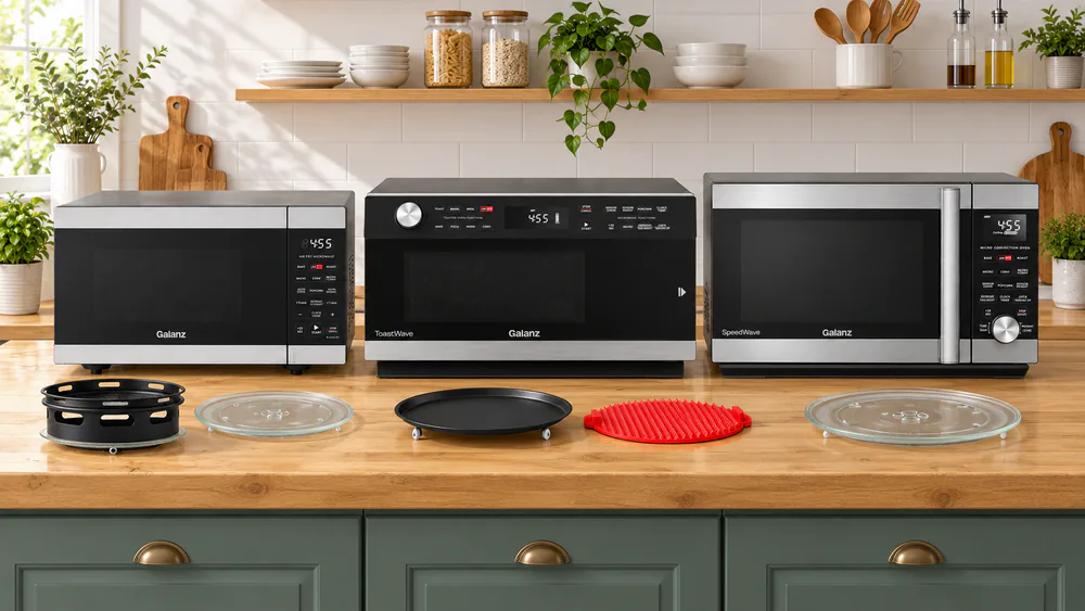 Three Galanz combo microwaves of different sizes lined up on a kitchen counter with their air fry racks and turntables set out in front