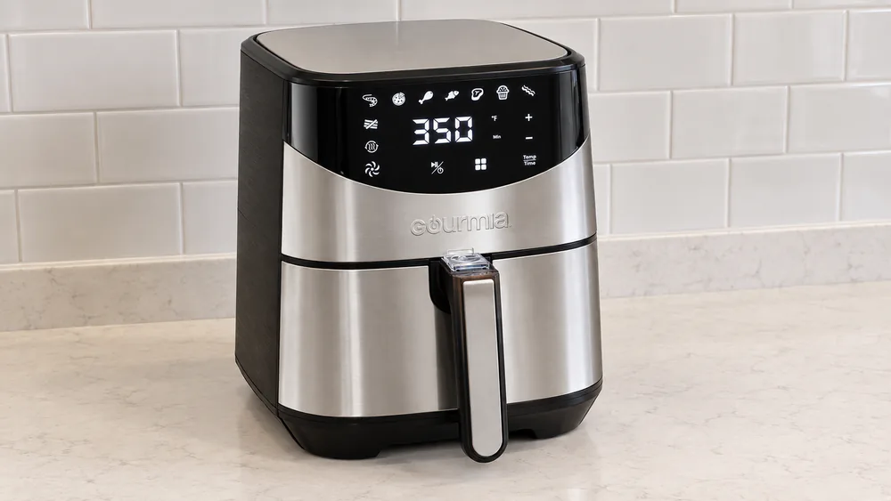 A Gourmia GAF645 stainless steel 6 quart air fryer on a kitchen counter with a few inches of clearance from the backsplash