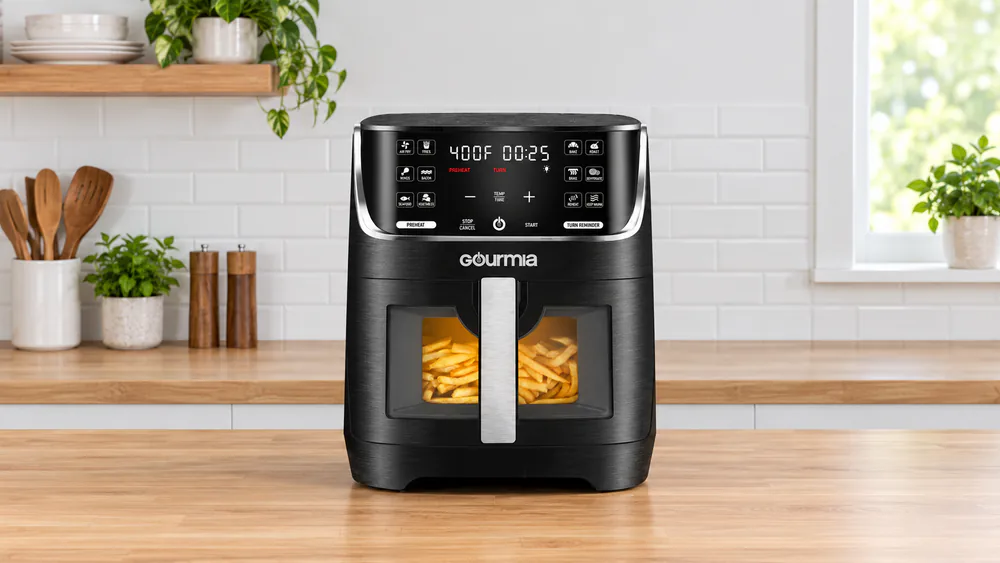 The Gourmia GAF824 window air fryer with its interior light on, golden fries visible through the glass