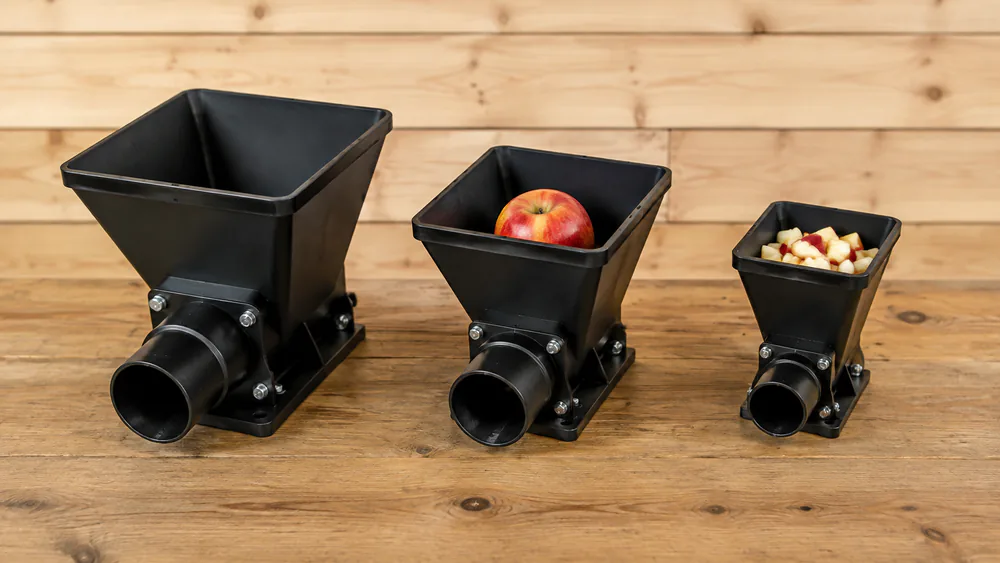 Three feed chutes side by side: 3.5 inch, 3 inch with an apple, and a 2 inch hopper with cut pieces.
