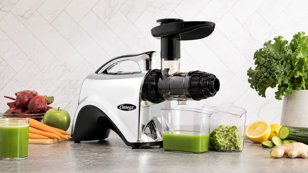 The Omega NC900HDC horizontal cold press juicer with its dual-stage auger drum and pulp ejection chute on the counter