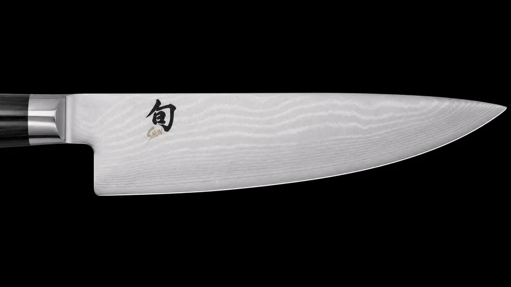 Close-up of a Shun Classic chef's knife showing the layered Damascus pattern along the blade.