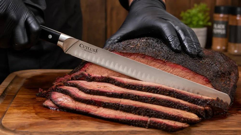 The Cutluxe 12-inch brisket knife slicing a smoked brisket on a wooden cutting board, clean even slices falling to the side.