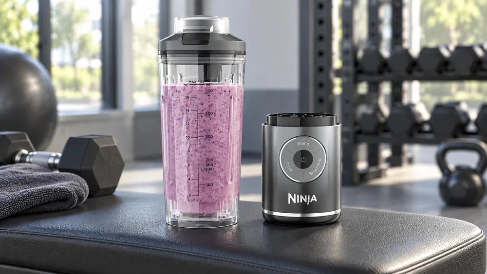 A Ninja Blast Max portable blender with its sip lid on a gym bench.
