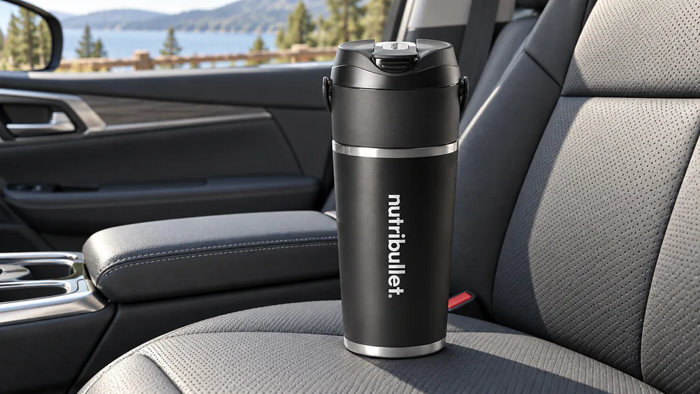 A NutriBullet Flip insulated stainless cup on a car seat with condensation-free sides and a sip lid.