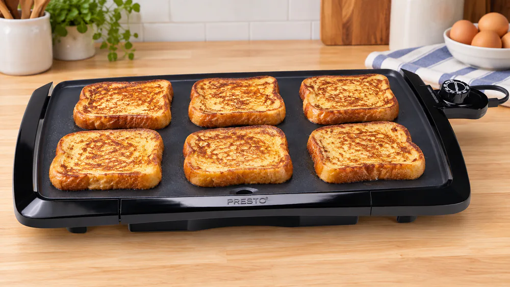 Presto 07030 20-inch griddle with a full row of golden French toast slices cooking across its length