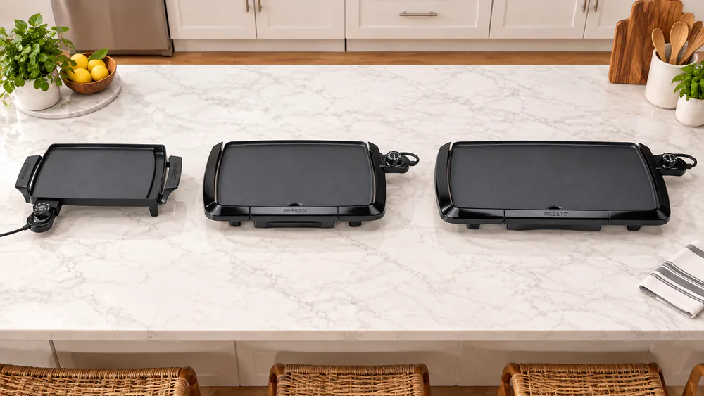 Overhead view of the Presto 07211, 07047 and 07030 griddles side by side on a counter, showing the difference in cooking surface length
