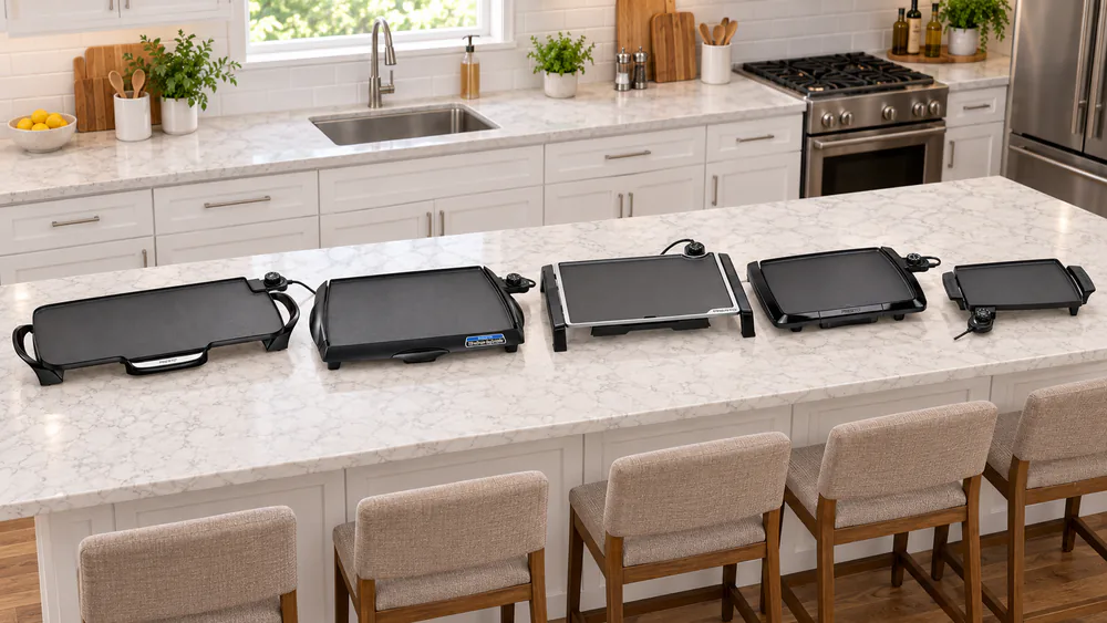 Five Presto electric griddles of different sizes lined up on a kitchen counter, from the 22-inch model to the small Liddle Griddle