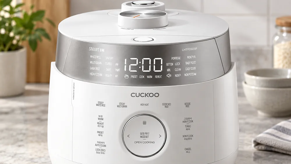 Close-up of the Cuckoo CRP-LHTR0609F control panel and LED display showing its pressure and grain mode options.