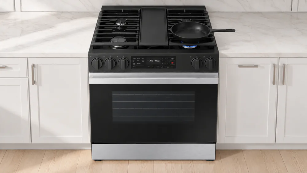 The five sealed burners of a Samsung Bespoke gas range lit under a skillet, with a griddle-compatible grate in place