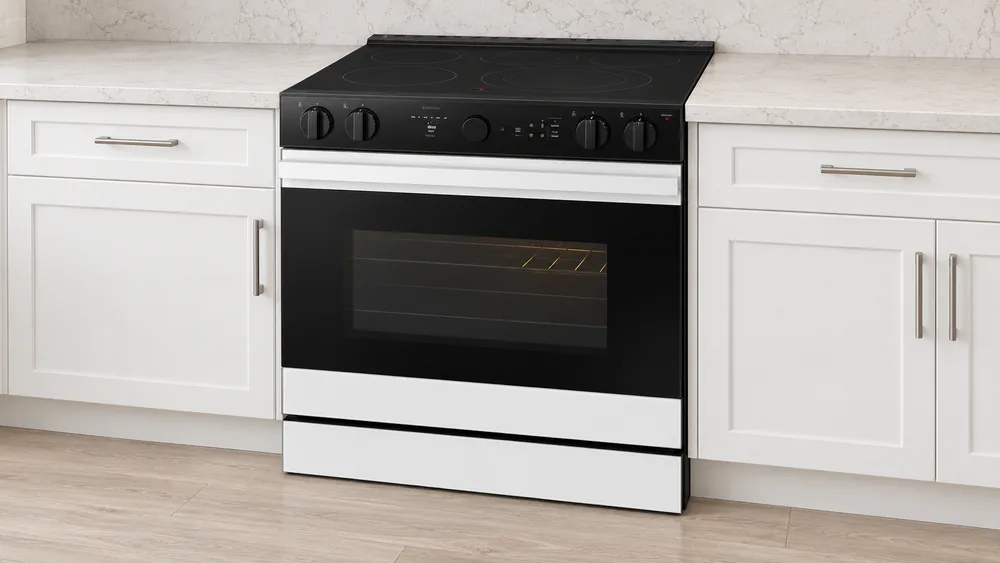 A white glass Samsung Bespoke AI slide-in range installed between counters with the precision knobs and LCD display visible