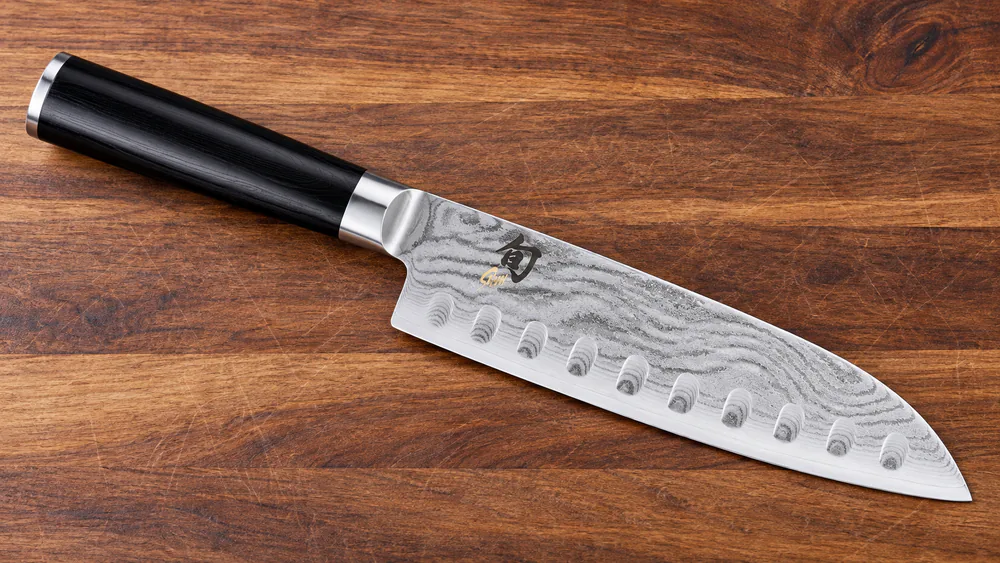 The Shun Classic 7-inch hollow ground santoku knife with a Damascus-pattern blade and D-shaped Pakkawood handle.