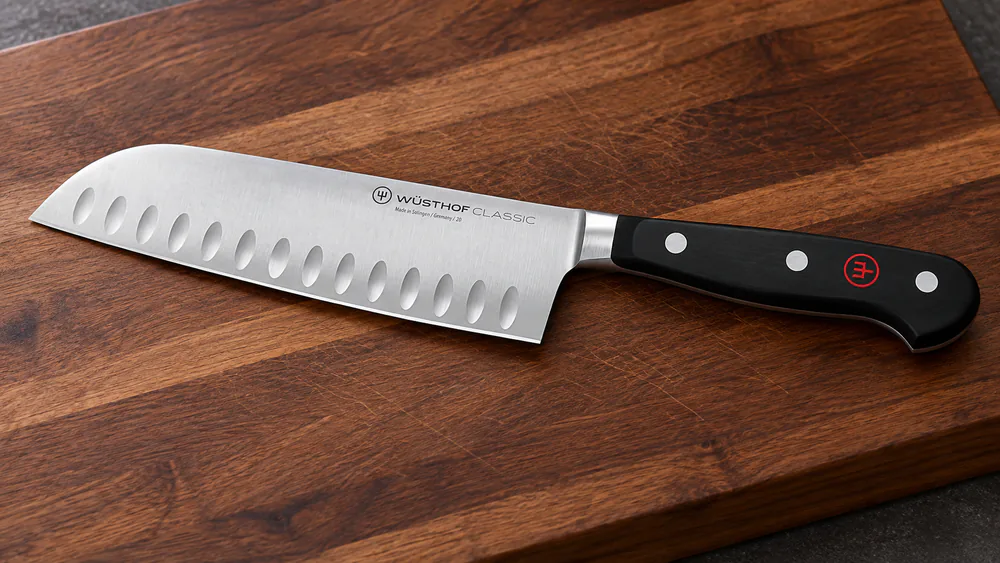 The Wüsthof Classic 7-inch santoku knife with a forged German steel blade and triple-riveted POM handle on a wooden cutting board.