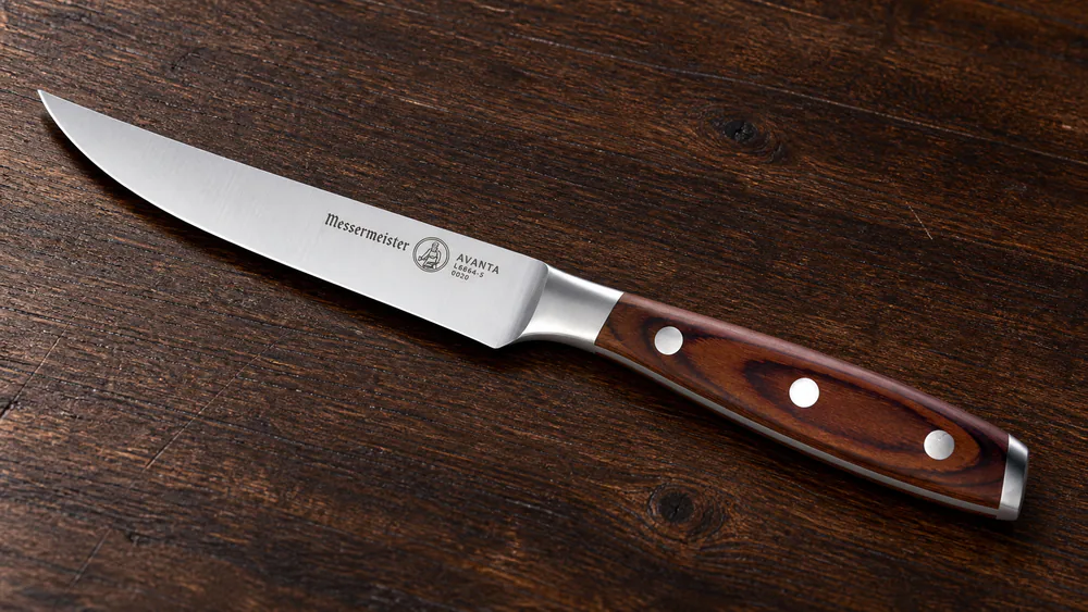 Close-up of the Messermeister Avanta showing the triple-rivet Pakkawood handle and solid bolster.