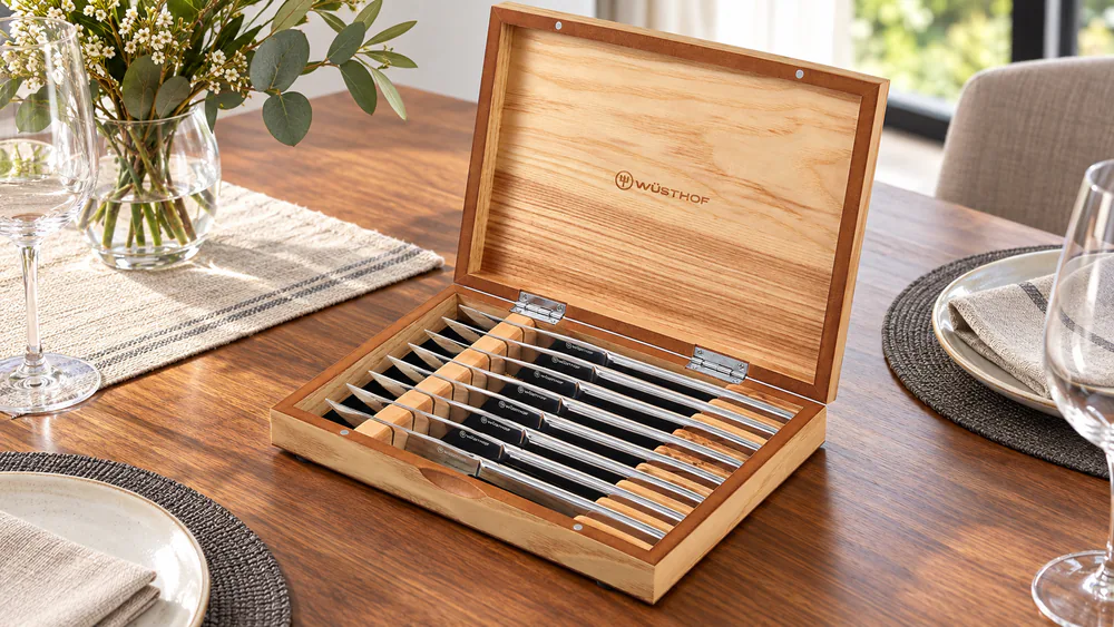 Wusthof Mignon steak knives laid in their acacia and olivewood presentation box.