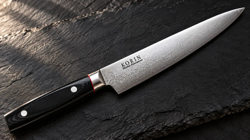 The 33-layer Damascus pattern on the Korin sujihiki blade catching the light.