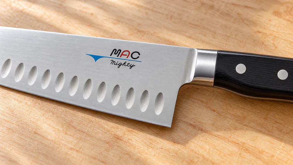 The MAC MTH-80 gyuto's Granton-style dimples releasing a slice of roasted beef.