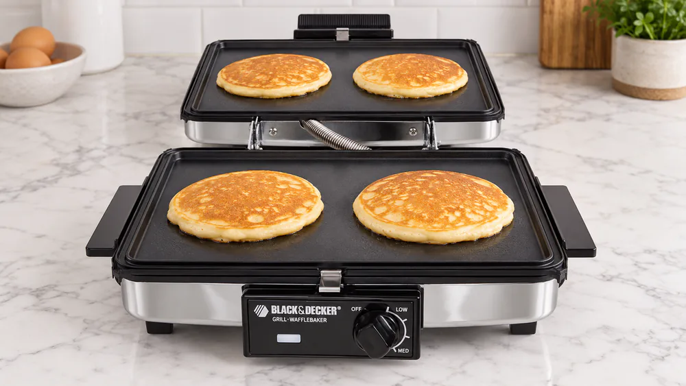 Black+Decker G49TD opened flat with the reversible plates turned to the griddle side and pancakes cooking on both surfaces