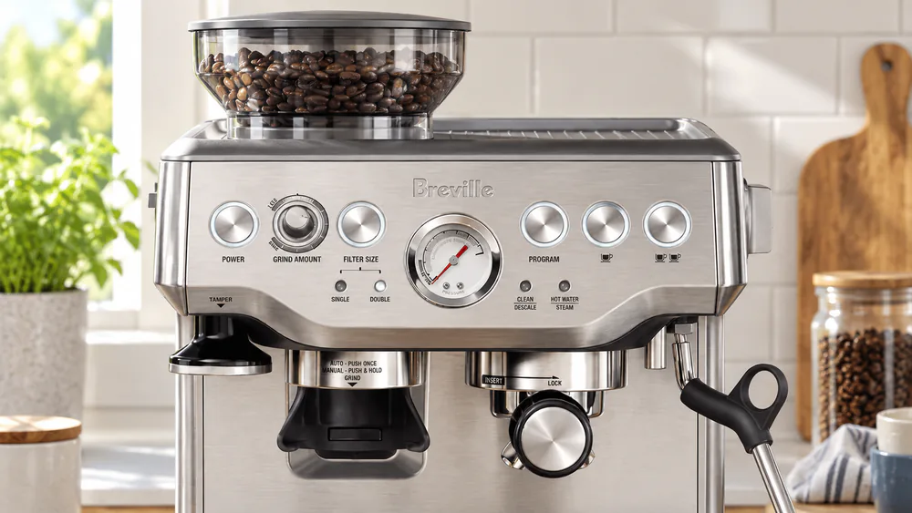 Close-up of the Breville Barista Express bean hopper and 16-step grind dial, beans feeding into the integrated conical burr grinder.