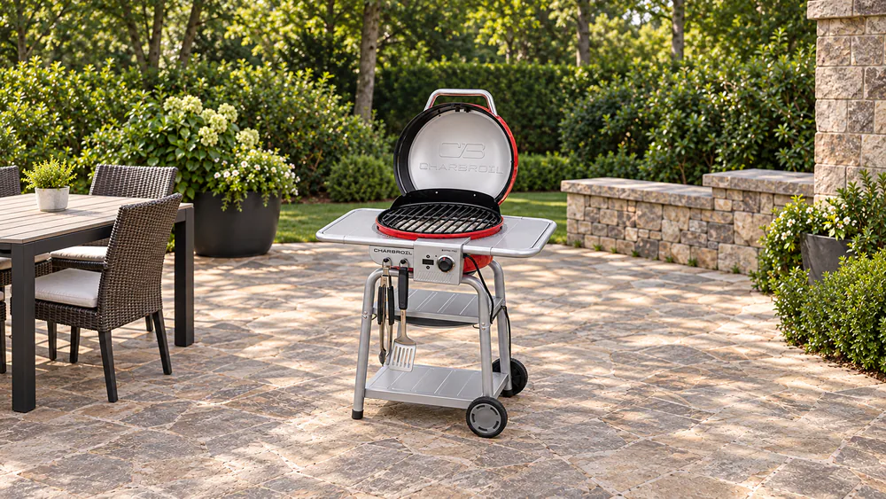 Ash-covered charcoal briquettes beneath the Char-Broil Bistro Pro cooking grate, with the lid open and the electric controller off after ignition