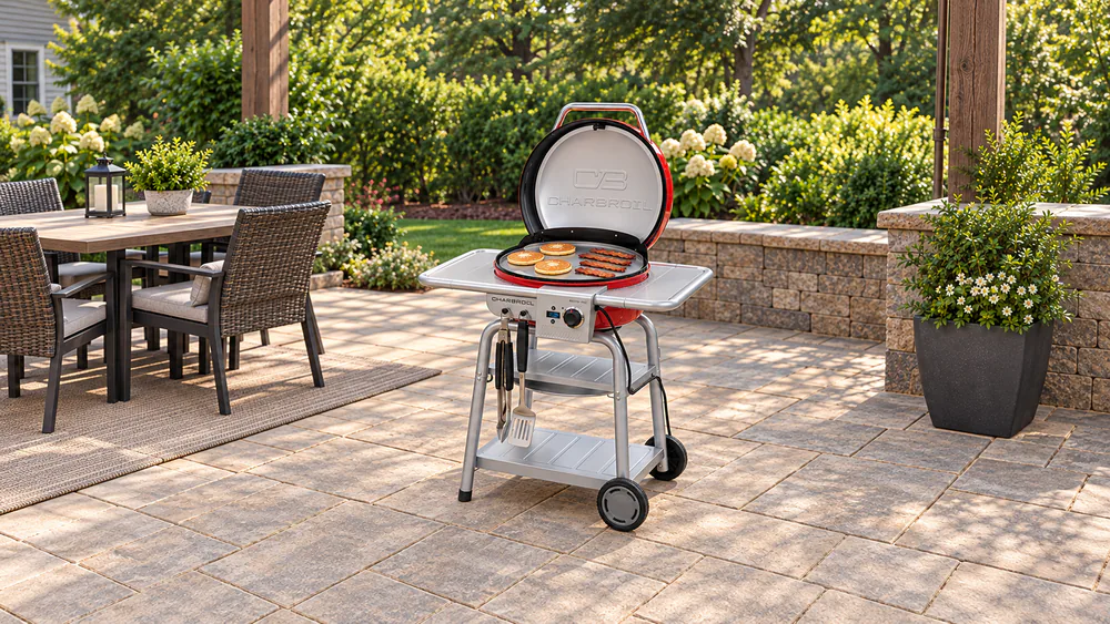 Stainless steel griddle insert on the Char-Broil Bistro Pro with pancakes and strips of bacon cooking on the surface