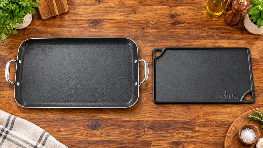 HexClad double burner griddle beside a Lodge cast iron reversible grill and griddle on a kitchen counter