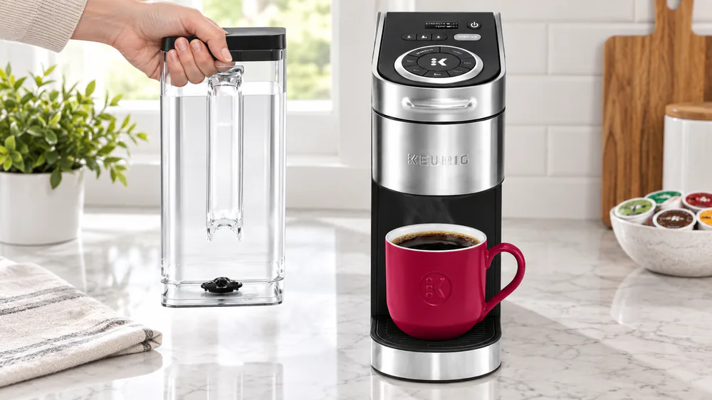 The removable 78 oz water reservoir of the Keurig K-Supreme Plus lifted by its molded carry handle beside the brewer on a kitchen counter.