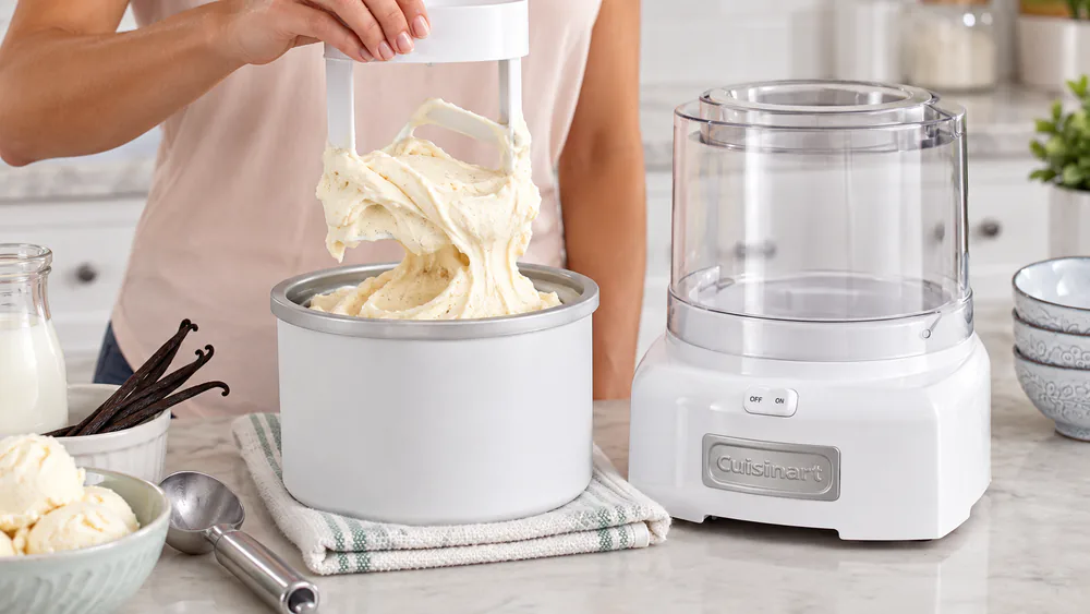 Freshly churned vanilla ice cream at the soft-serve stage mounded on a Cuisinart dasher lifted from the frozen bowl.