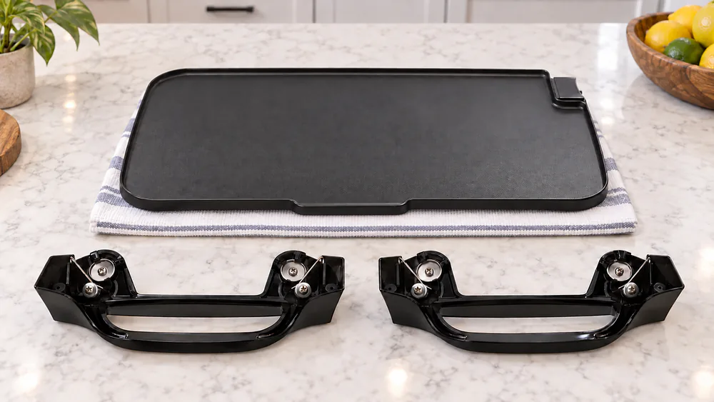 The Presto 22-inch griddle base with both latch-clip handles detached and laid beside it on a kitchen counter