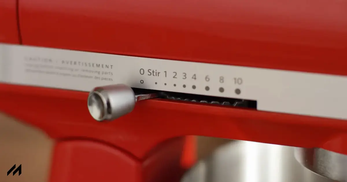 Close-up of a red stand mixer’s control panel, showing the speed settings from "0 Stir" to "10" with a silver adjustment lever.