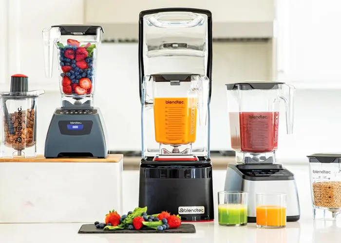 _Blendtec Stealth 885 Commercial Blender Blendtec Stealth 885 commercial blender with sound enclosure blending a smoothie on a countertop, surrounded by jars and fresh ingredients.