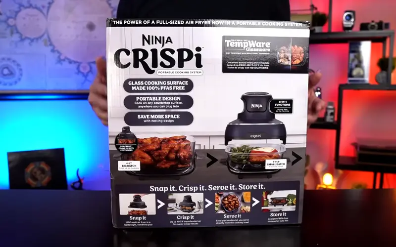 Ninja Crispi portable air fryer box showing glass cooking surface, compact design, and snap-crisp-serve system