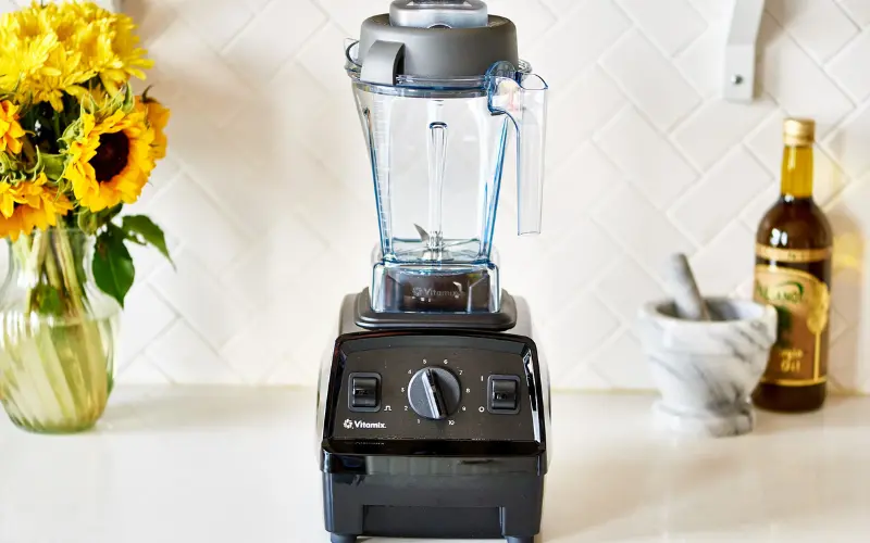 Vitamix Explorian E310 Blender Review Vitamix Explorian E310 blender on a kitchen counter with variable speed dial and clear blending jar