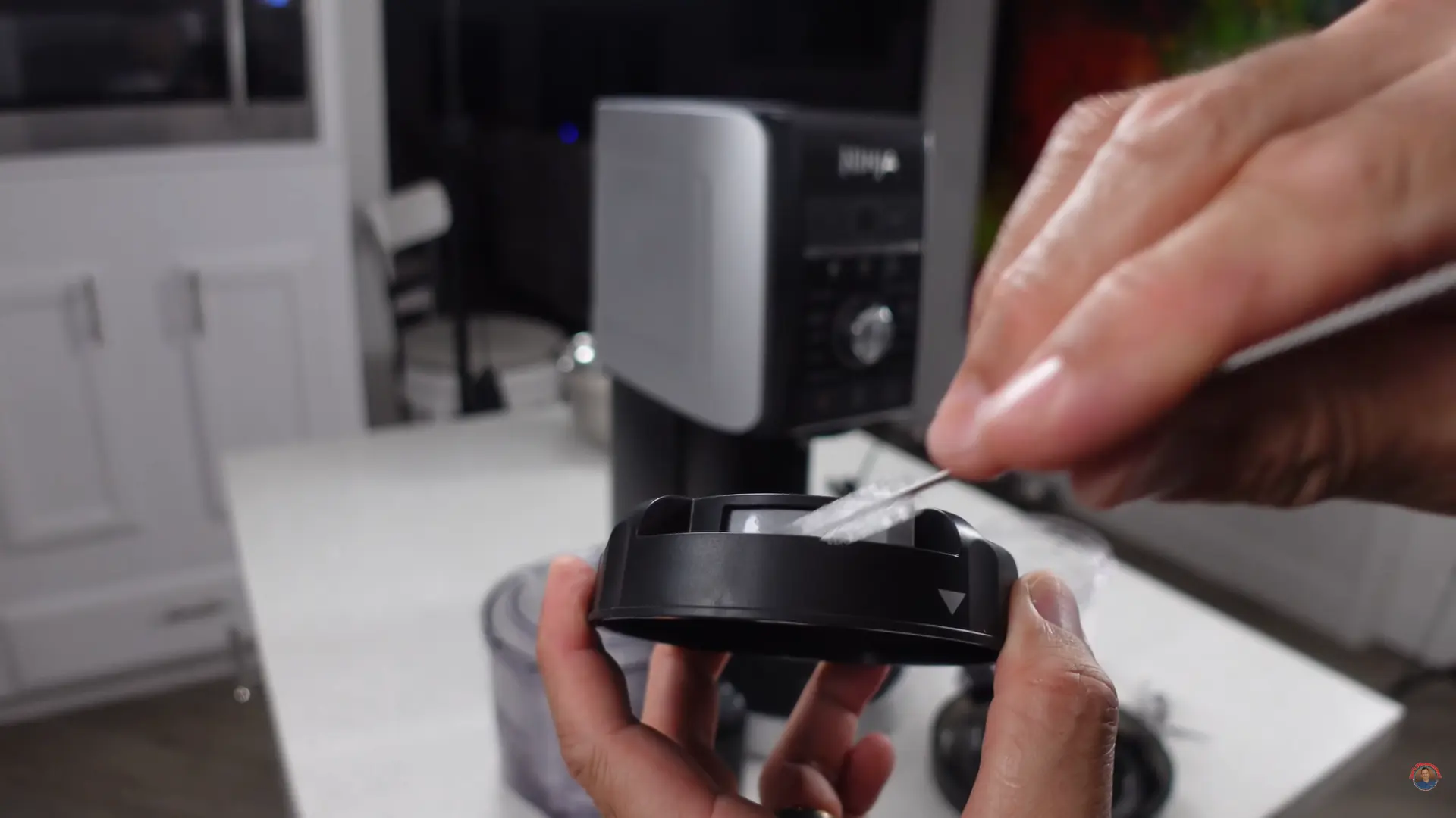 All Ninja CREAMi parts disassembled and laid out before cleaning including paddle, pint, lid, gasket, and motor base